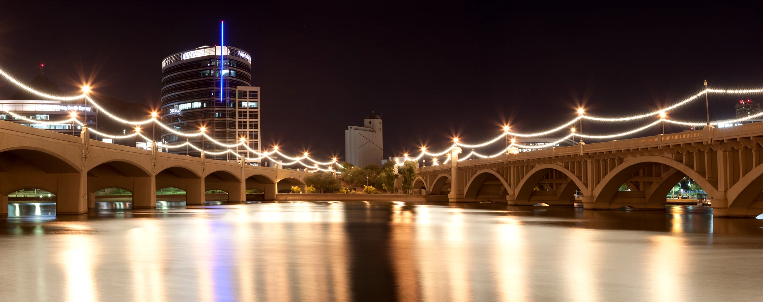 Tempe Town Lake and the illuminated Mill Avenue bridges beneath the Tempe skyline